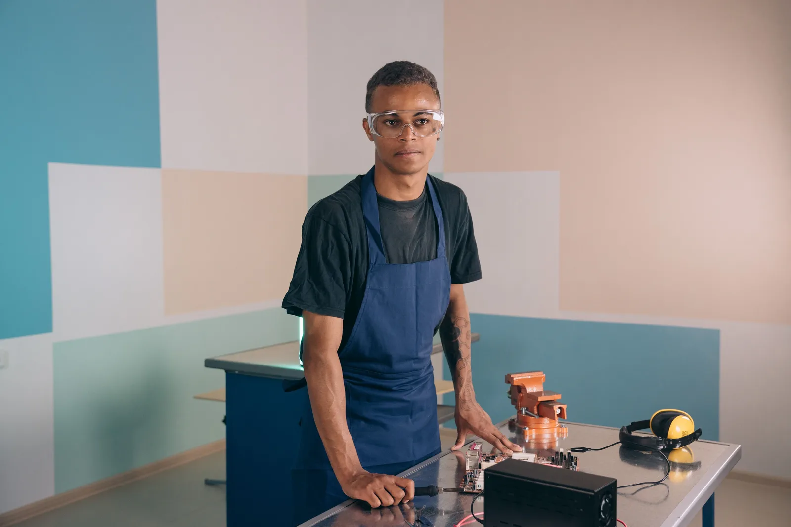 Technicien en formation, équipé de lunettes de protection, à son poste de travail